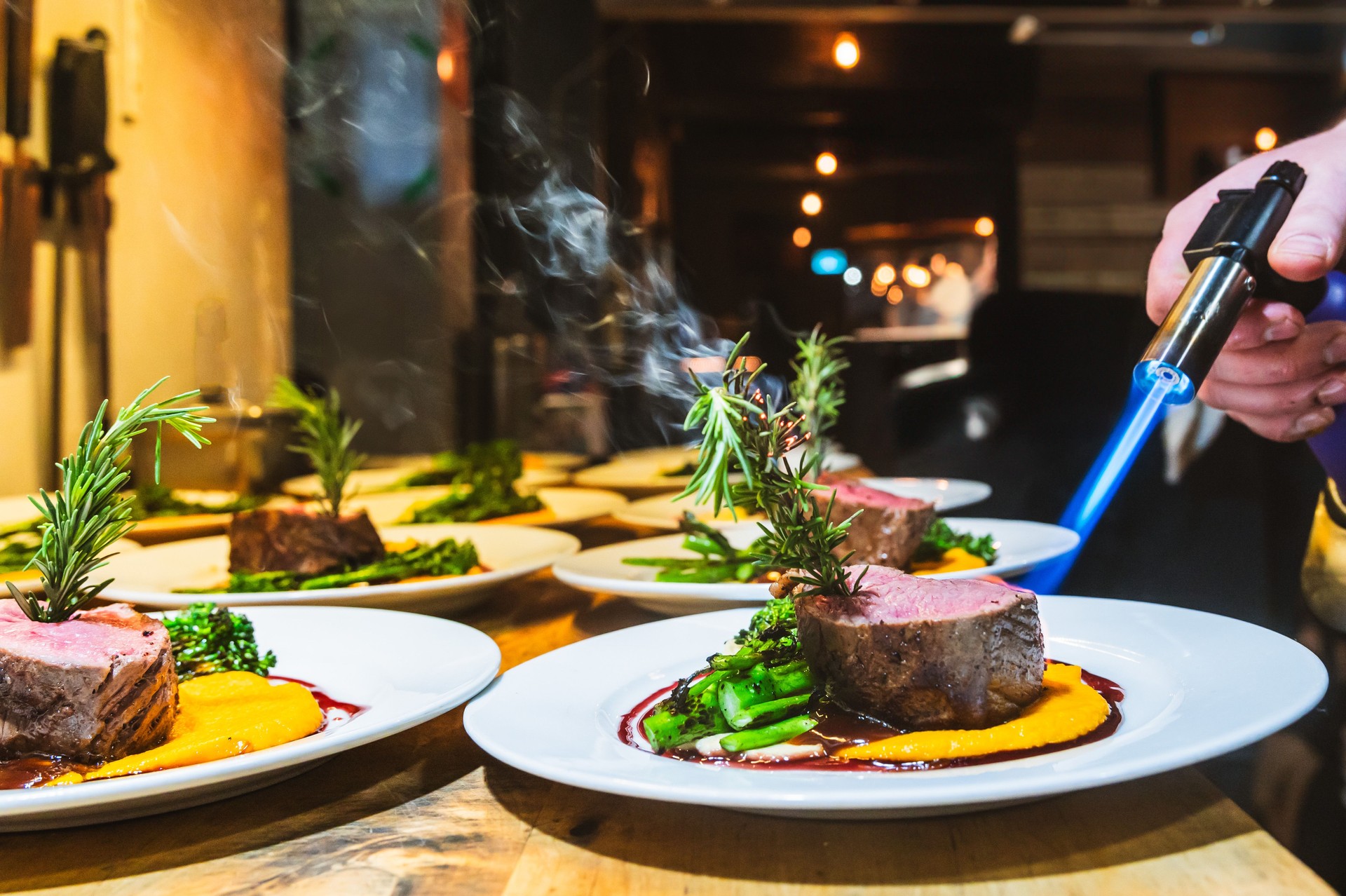 Kitchen Chef prepairing Steaks in a Restaurant